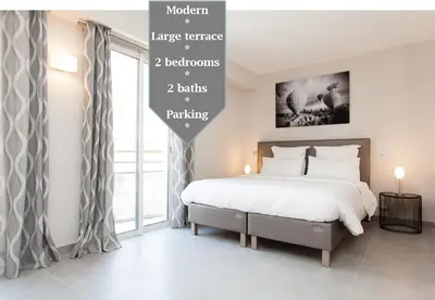 a bedroom with a bed and a large window at Carlton area: New 2 beds / 2 baths in Cannes