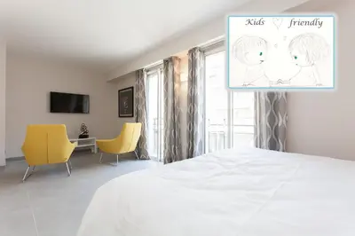 a bedroom with a white bed and yellow chairs at Carlton area: New 2 beds / 2 baths in Cannes