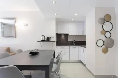 a kitchen with a black table and white cabinets at Carlton area: New 2 beds / 2 baths in Cannes