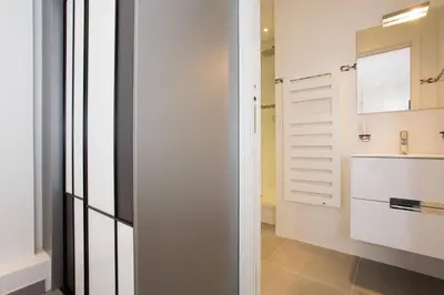 a bathroom with white walls and a sink and a mirror at MARTINEZ AREA: NEW 2BEDS/2BATHS in Cannes