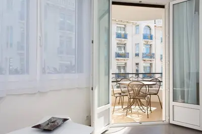 a room with a balcony with a table and chairs at MARTINEZ AREA: NEW 2BEDS/2BATHS in Cannes