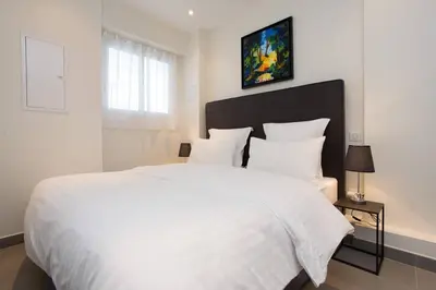 a bedroom with a large white bed with white pillows at MARTINEZ AREA: NEW 2BEDS/2BATHS in Cannes