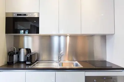 a stainless steel kitchen with a sink and a microwave at 1 bedroom in front of the Palais! in Cannes