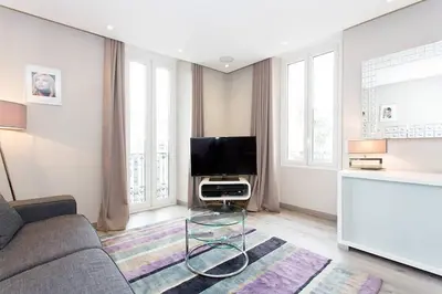 a living room with a couch and a flat screen tv at 1 bedroom in front of the Palais! in Cannes