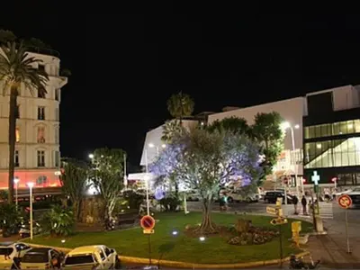 a city street at night with cars parked in front of a building at 1 bedroom in front of the Palais! in Cannes