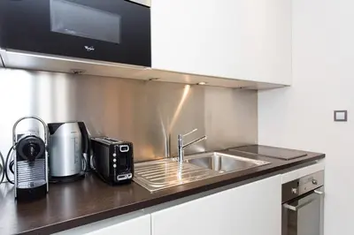 a kitchen counter with a sink and a microwave at 1 bedroom in front of the Palais! in Cannes