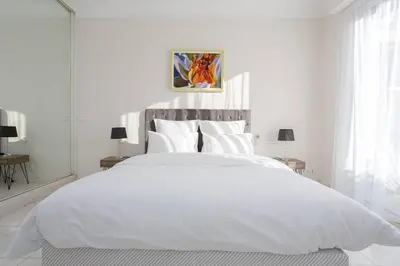 a white bedroom with a large white bed with white sheets at MARIOTT AREA: SUNNY 2 BEDS /2 BATHS in Cannes
