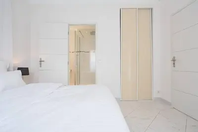 a bedroom with a white bed and a walk in shower at MARIOTT AREA: SUNNY 2 BEDS /2 BATHS in Cannes