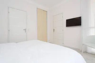 a white bedroom with a bed and a tv at MARIOTT AREA: SUNNY 2 BEDS /2 BATHS in Cannes