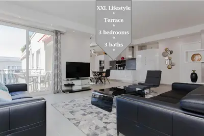 a living room with a couch and a tv at Marriott- Croisette: Superb 3 bedrooms/ 3 baths in Cannes
