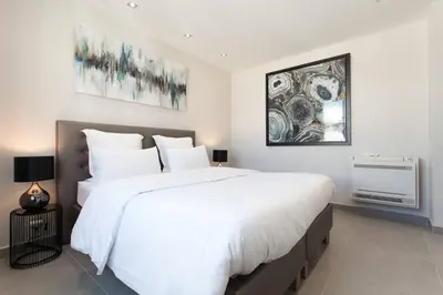 a bedroom with a large bed with white sheets at Marriott- Croisette: Superb 3 bedrooms/ 3 baths in Cannes