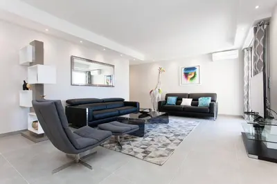 a living room with a black leather couch and chairs at Marriott- Croisette: Superb 3 bedrooms/ 3 baths in Cannes