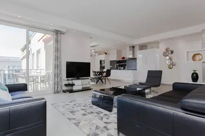 a living room with a couch and a tv at Marriott- Croisette: Superb 3 bedrooms/ 3 baths in Cannes