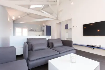 a living room with a couch and a tv at Top floor2 beds w/sea wiew in Cannes