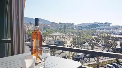 a bottle of wine sitting on a table with two glasses at Top floor2 beds w/sea wiew in Cannes