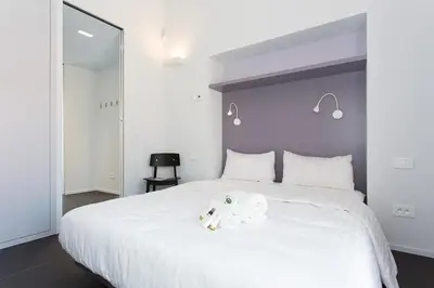 a white bed with two stuffed animals on it at Top floor2 beds w/sea wiew in Cannes