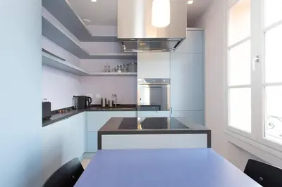 a kitchen with white cabinets and a table with chairs at Pure & chic 2beds/2baths in centre! in Cannes
