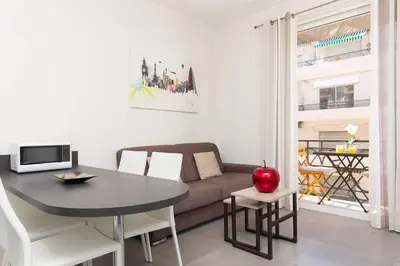 a living room with a table and a couch at Palais Miramar: 1 bed side sea view in Cannes