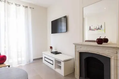 a living room with a fireplace and a tv at Palais Miramar: 1 bed side sea view in Cannes
