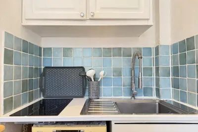 a kitchen with a sink and blue tiles on the wall at 1-bedroom appartement in the center of Cannes in Cannes