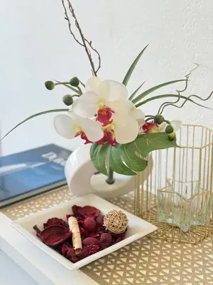 a table with a vase with flowers and a plate of food at 1-bedroom appartement in the center of Cannes in Cannes