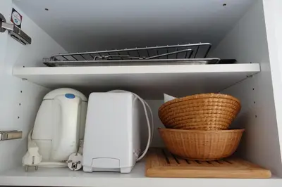 a kitchen drawer with a white appliance and baskets at Eden Beach in Cannes