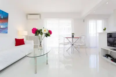 a white living room with a white couch and a glass table at MARRIOTT/ CROISETTE - LUXE 1 BED in Cannes