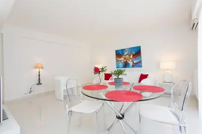 a white dining room with a glass table and chairs at MARRIOTT/ CROISETTE - LUXE 1 BED in Cannes