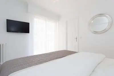 a white bedroom with a bed and a mirror at MARRIOTT/ CROISETTE - LUXE 1 BED in Cannes