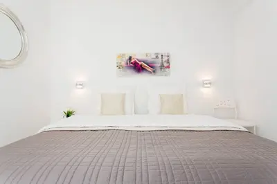 a white bedroom with a bed and a painting on the wall at MARRIOTT/ CROISETTE - LUXE 1 BED in Cannes