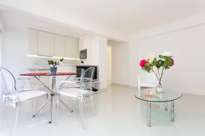 a living room with a table and chairs and a kitchen at MARRIOTT/ CROISETTE - LUXE 1 BED in Cannes