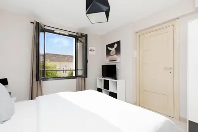 a bedroom with a white bed and a window at 3 bedrooms: 200m from Croisette in Cannes