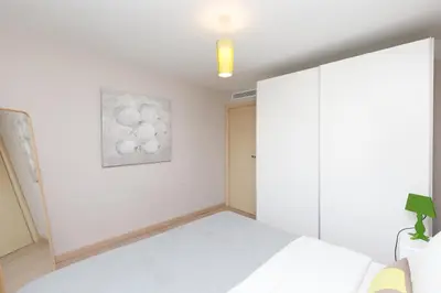 a white bedroom with a bed and a painting on the wall at 3 bedrooms: 200m from Croisette in Cannes