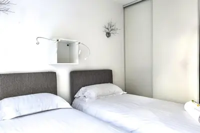 two beds sitting next to each other in a room at IMMOGROOM - 3min from beach - AC - 10min from Palais - Wifi in Cannes