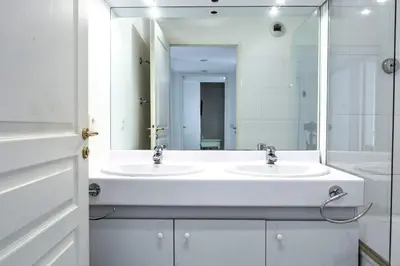 a white bathroom with two sinks and a mirror at IMMOGROOM - 3min from beach - AC - 10min from Palais - Wifi in Cannes