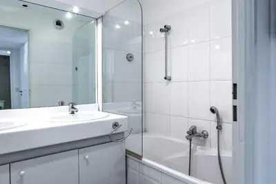 a white bathroom with a sink and a shower at IMMOGROOM - 3min from beach - AC - 10min from Palais - Wifi in Cannes