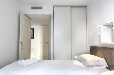 a bedroom with a white bed and a mirror at IMMOGROOM - 3min from beach - AC - 10min from Palais - Wifi in Cannes