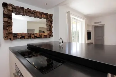 a kitchen with a black counter top and a mirror at 3 pièces Luxe Croisette in Cannes