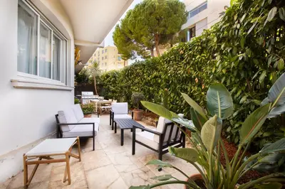 a patio with chairs and tables and plants at 3 pièces Luxe Croisette in Cannes