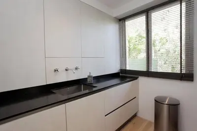 a kitchen with white cabinets and a sink and a window at 3 pièces Luxe Croisette in Cannes