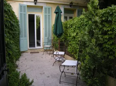 a patio with two chairs and a green umbrella at Croisette-Oasis in Cannes