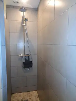 a shower in a bathroom with a tile wall at Croisette-Oasis in Cannes