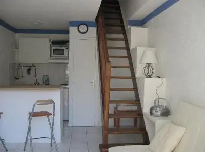 a staircase in a kitchen with a clock on the wall at Croisette-Oasis in Cannes
