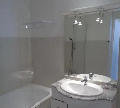 a bathroom with a sink and a tub and a mirror at Croisette-Oasis in Cannes