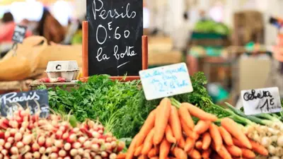 a vegetable stand with carrots and other vegetables on display at Colombe in Cannes