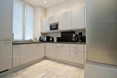 a kitchen with white cabinets and a microwave at Colombe in Cannes