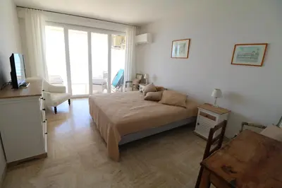 a bedroom with a bed and a desk and a window at Amazing sea view 2 bedroom beach front 303 in Cannes