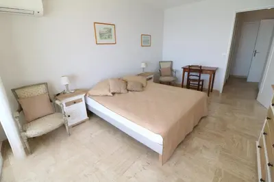 a bedroom with a bed and a table and chairs at Amazing sea view 2 bedroom beach front 303 in Cannes