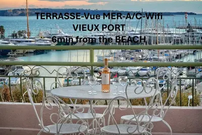 a bottle of wine sitting on a table on a balcony at Superbe Duplex TERRASSE vue MER, FELIX FAURE- FORVILLE A1B059 in Cannes