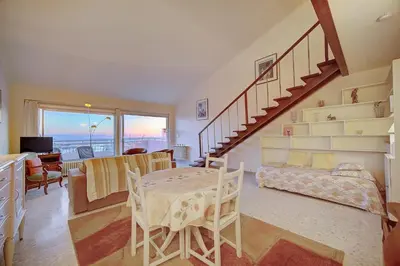 a living room with a staircase and a table and chairs at Superbe Duplex TERRASSE vue MER, FELIX FAURE- FORVILLE A1B059 in Cannes